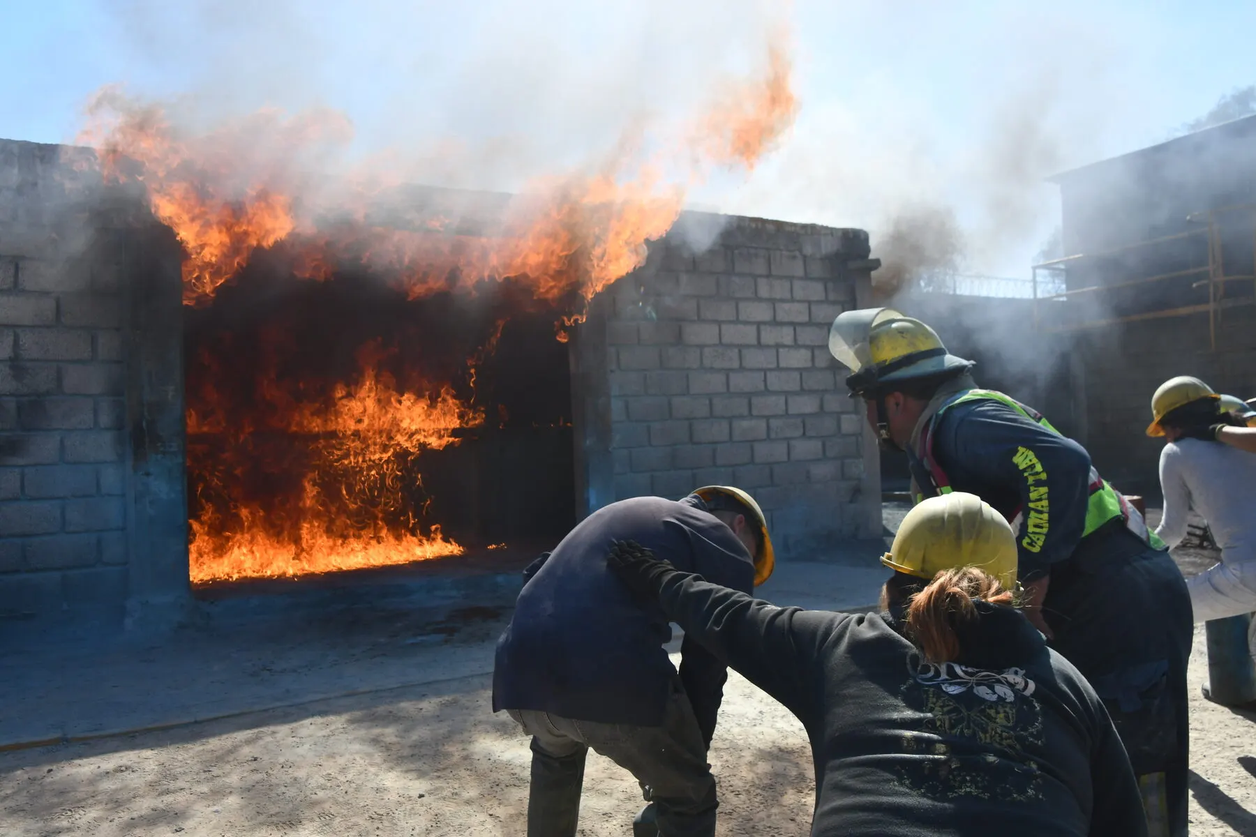 Brigada entra con extintores a un cuarto en llamas