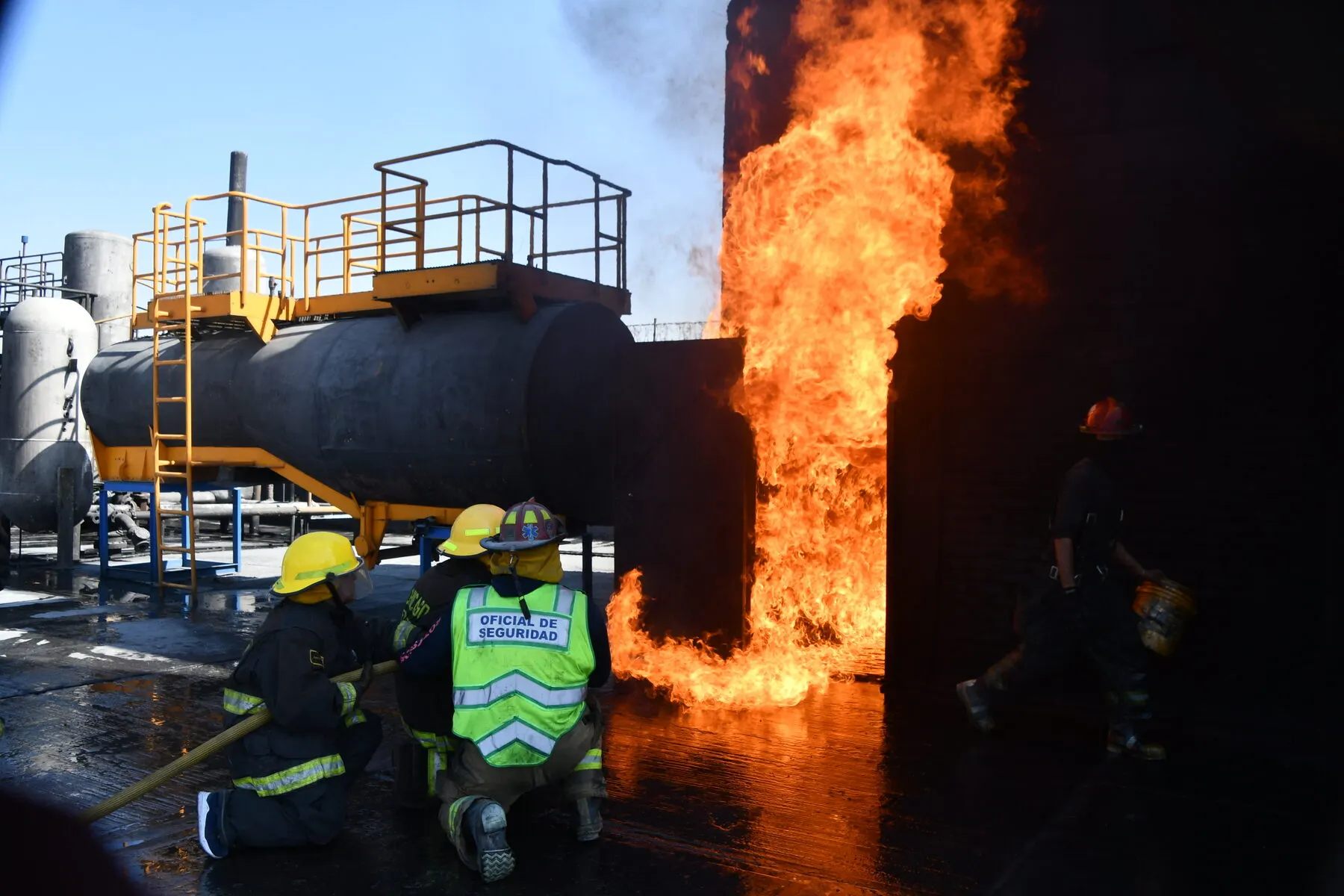 Brigadistas atacan el incendio de un tanque