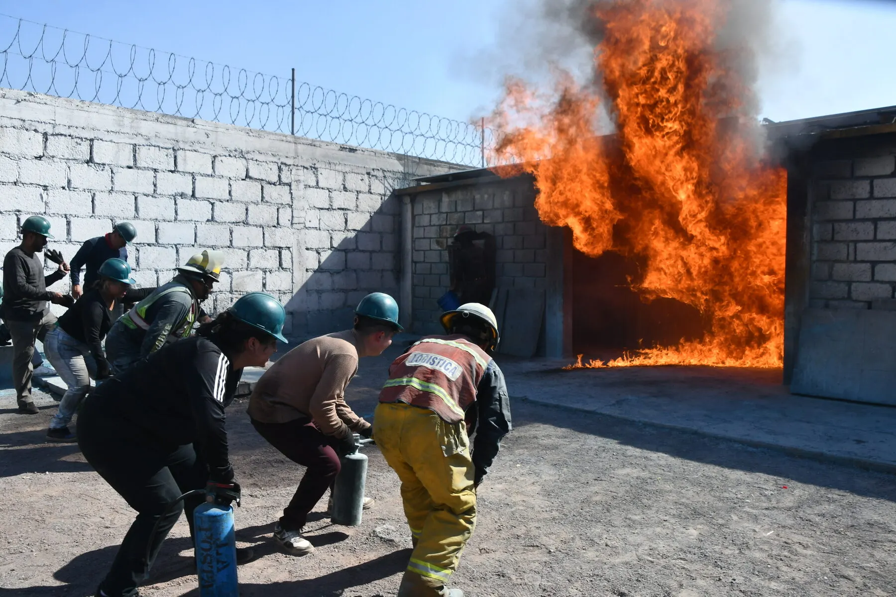 Grupo avanza con extintores hacia un incendio