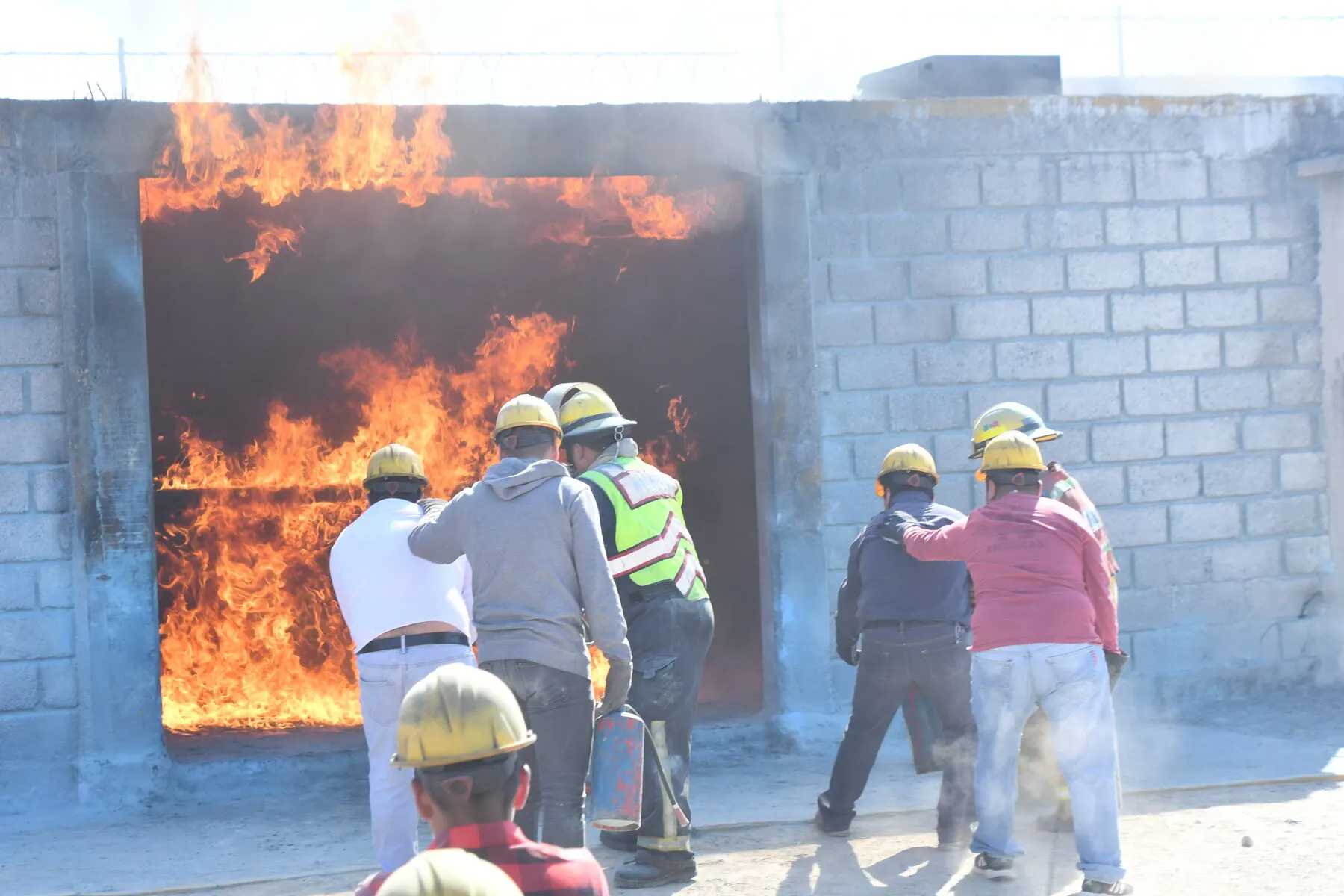 Brigada frente a una fachada en llamas